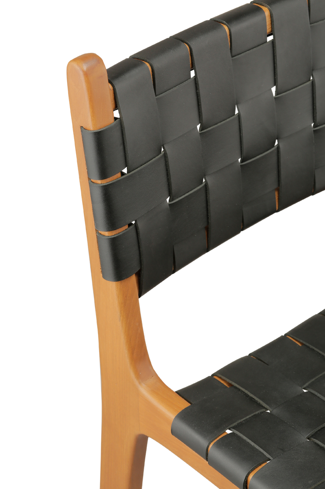 Close up view of the chair. A wooden counter stool with a woven black leather seat and back, shown against a transparent background.