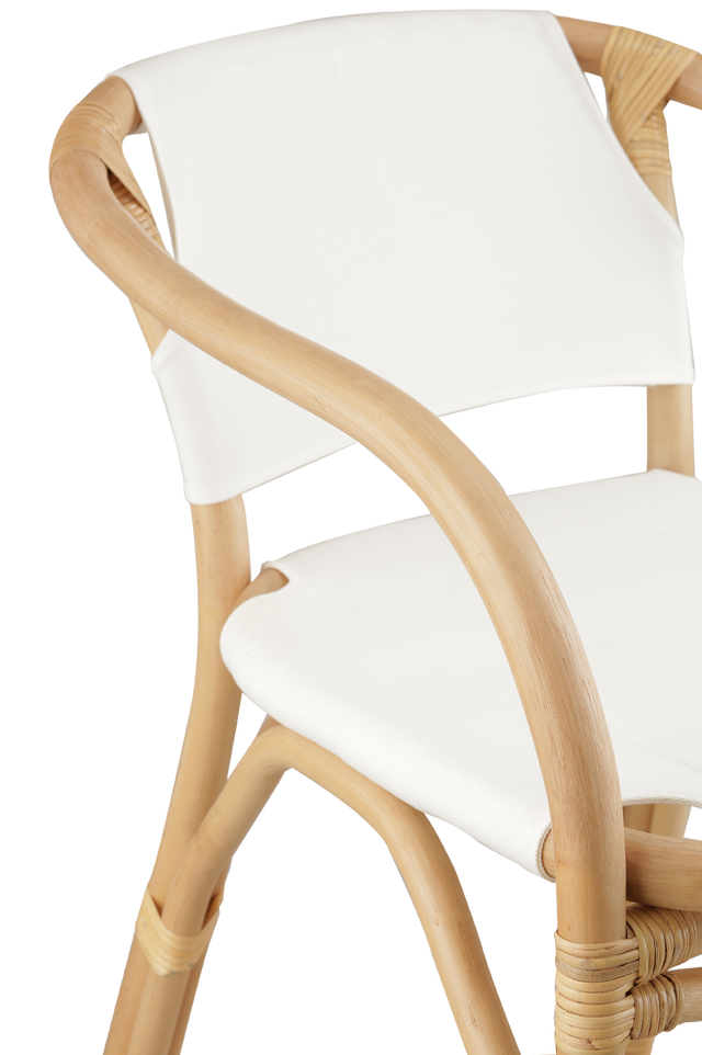 Close up of the side. A natural rattan-style counter stool with a curved frame, white padded seat and back, and woven accents, shown against a transparent background.