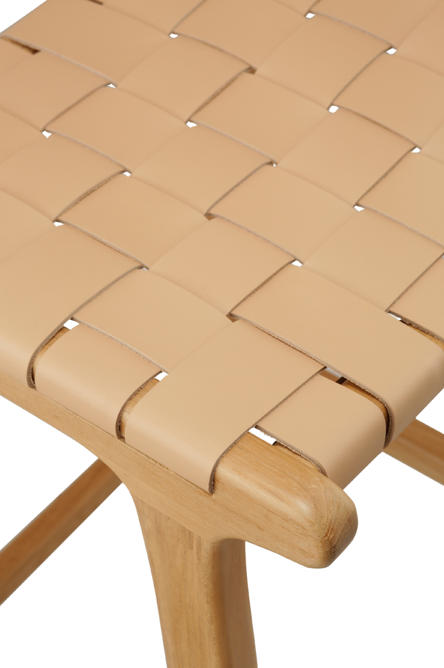 Close up of the leather. sleek counter stool with a wooden frame and a leather strap seat. The seat is made of woven tan leather strips, creating a modern, minimalist look. The frame is simple, with straight wooden legs and a crossbar for added support. 