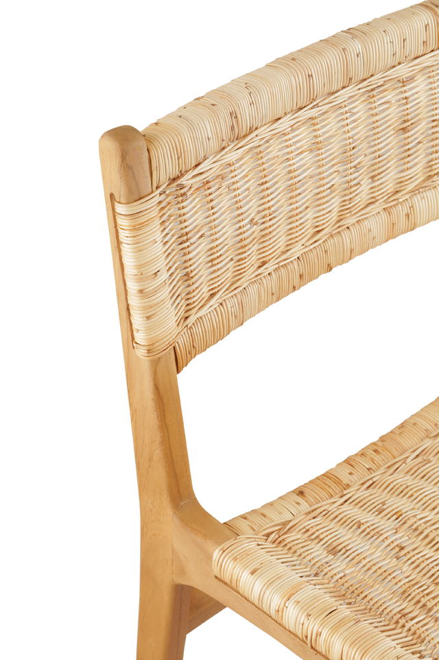 Close up of the weave. A wooden counter stool featuring a woven rattan seat and back, shown against a transparent background