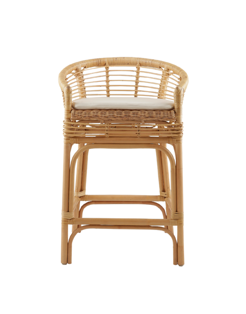 comfortable counter stool made from rattan, featuring a woven seat and backrest with armrests. The stool has a cushioned seat for added comfort and a natural rattan frame with intricate weaving. Its relaxed yet stylish design makes it a perfect fit for modern or coastal-inspired interiors.