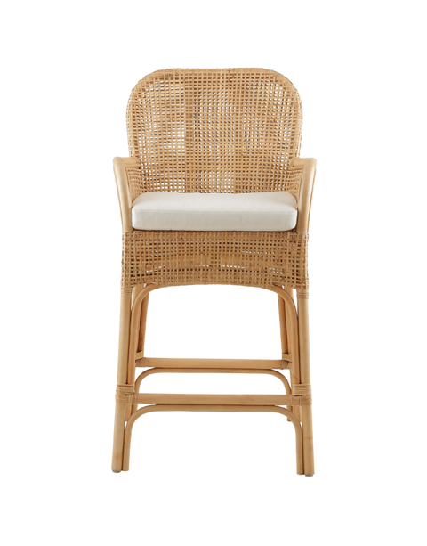 stylish counter stool made entirely from rattan, featuring a woven seat and backrest. The stool includes armrests and a cushioned seat for added comfort. The natural rattan frame is intricately woven, giving the stool a chic, relaxed look, perfect for modern or coastal-inspired interiors.