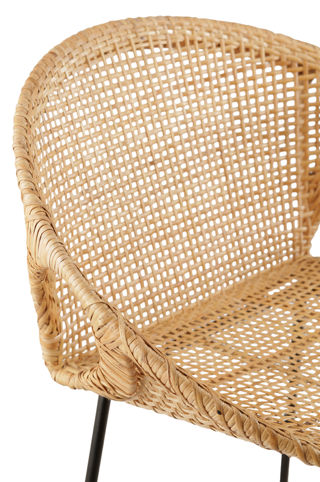 Close up of the material. stylish counter stool with a round, woven rattan seat. The seat is supported by slim black metal legs, offering a modern contrast to the natural texture of the rattan. The design features small cut-out sections at the sides of the seat.