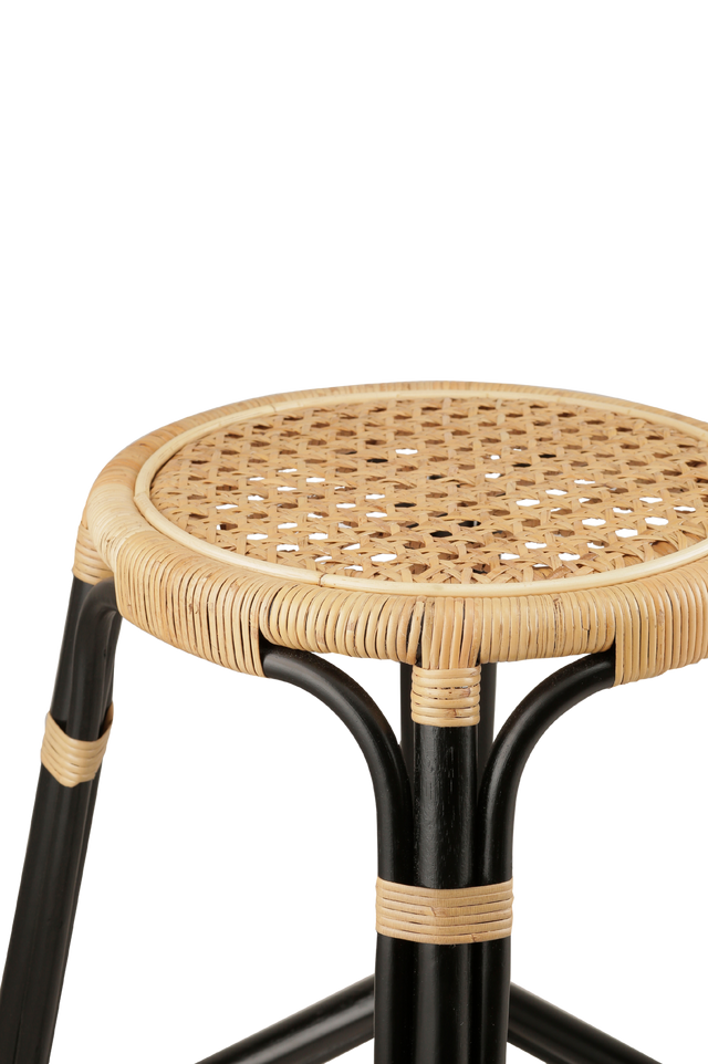 Close up of the material. A rattan counter stool with a round woven seat and black frame accented with natural rattan bindings, shown against a transparent background.