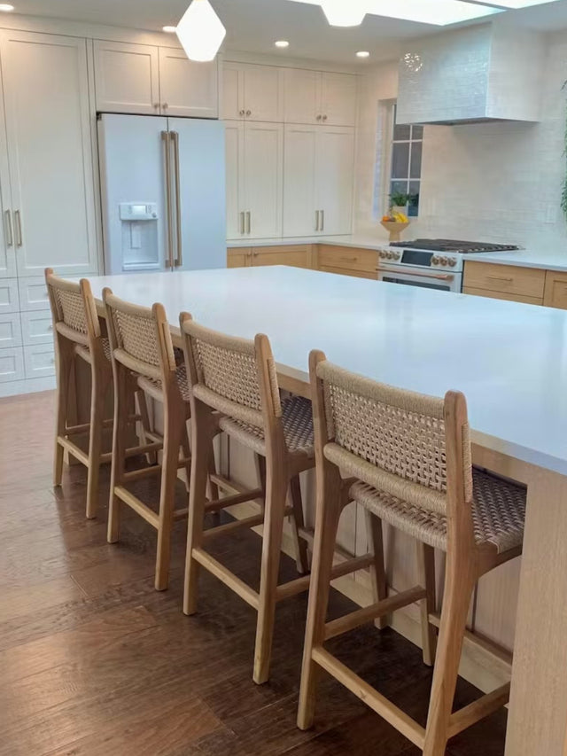 Teak counter stools with rope woven backs at a white oak modern kitchen island, easy to clean and kid friendly, designed for everyday family use